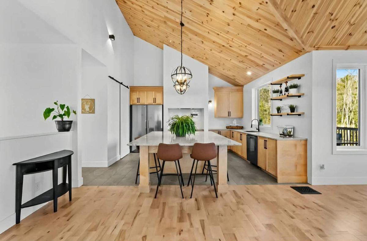 Cuisine à aire ouverte avec poutres de bois et plancher flottant, Immo GB