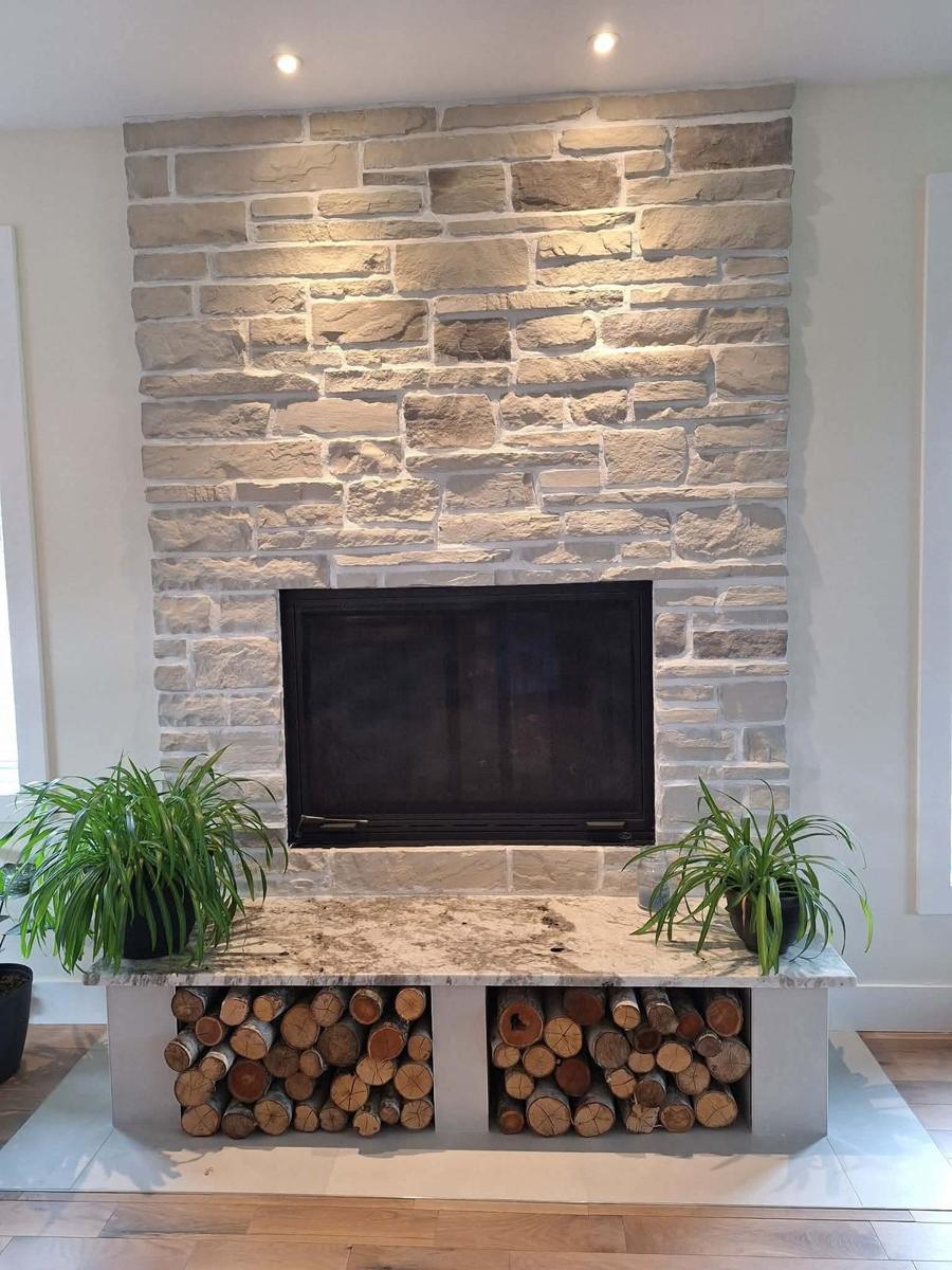 Foyer en pierre avec rangement de bois de chauffage, intérieur moderne Immo GB